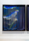 A luminous fabric framed and hung on a white wall