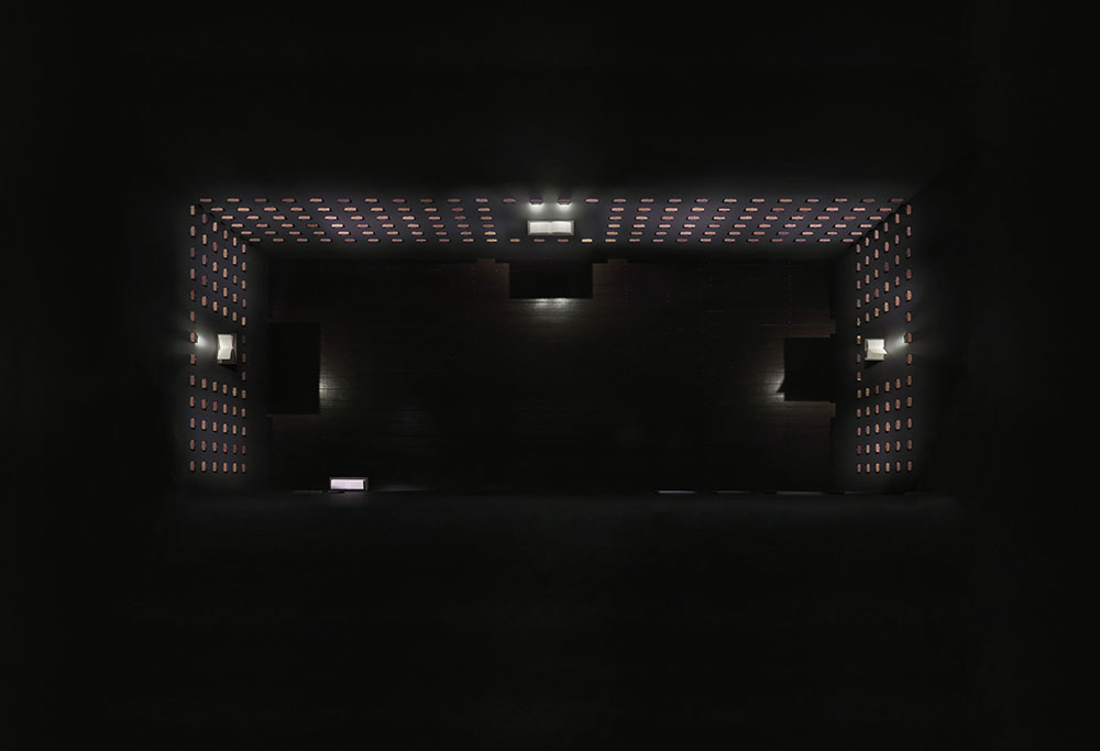 A bird's eye view of a dark room with boxes attached to the walls.