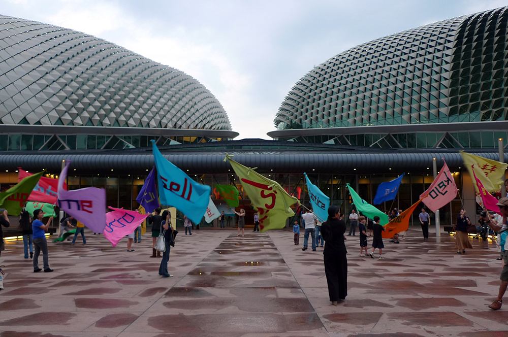 People holding different flags beneath the Esplanade.