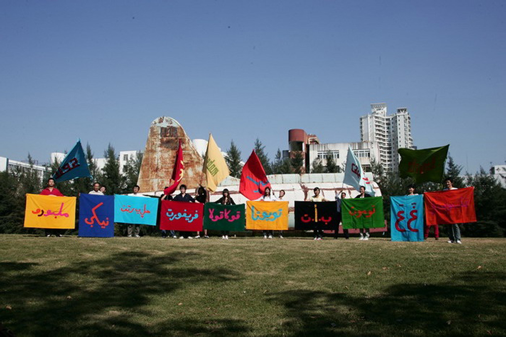 People holding flags and signs in various languages.