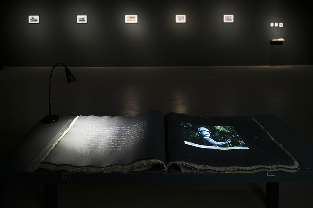 A book laid out on a podium in a dark room.