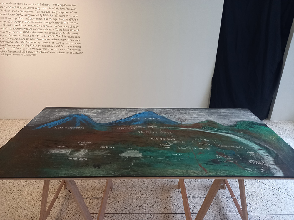 A table with a chalk drawing of mountains and land.