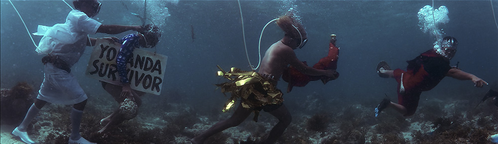 Men underwater carrying items.