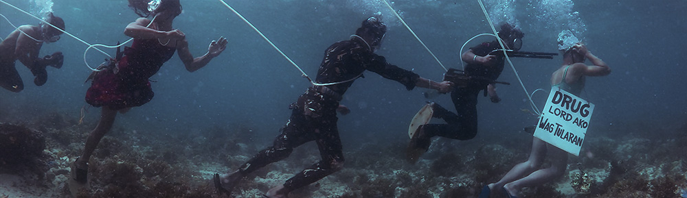 Men underwater carrying items.