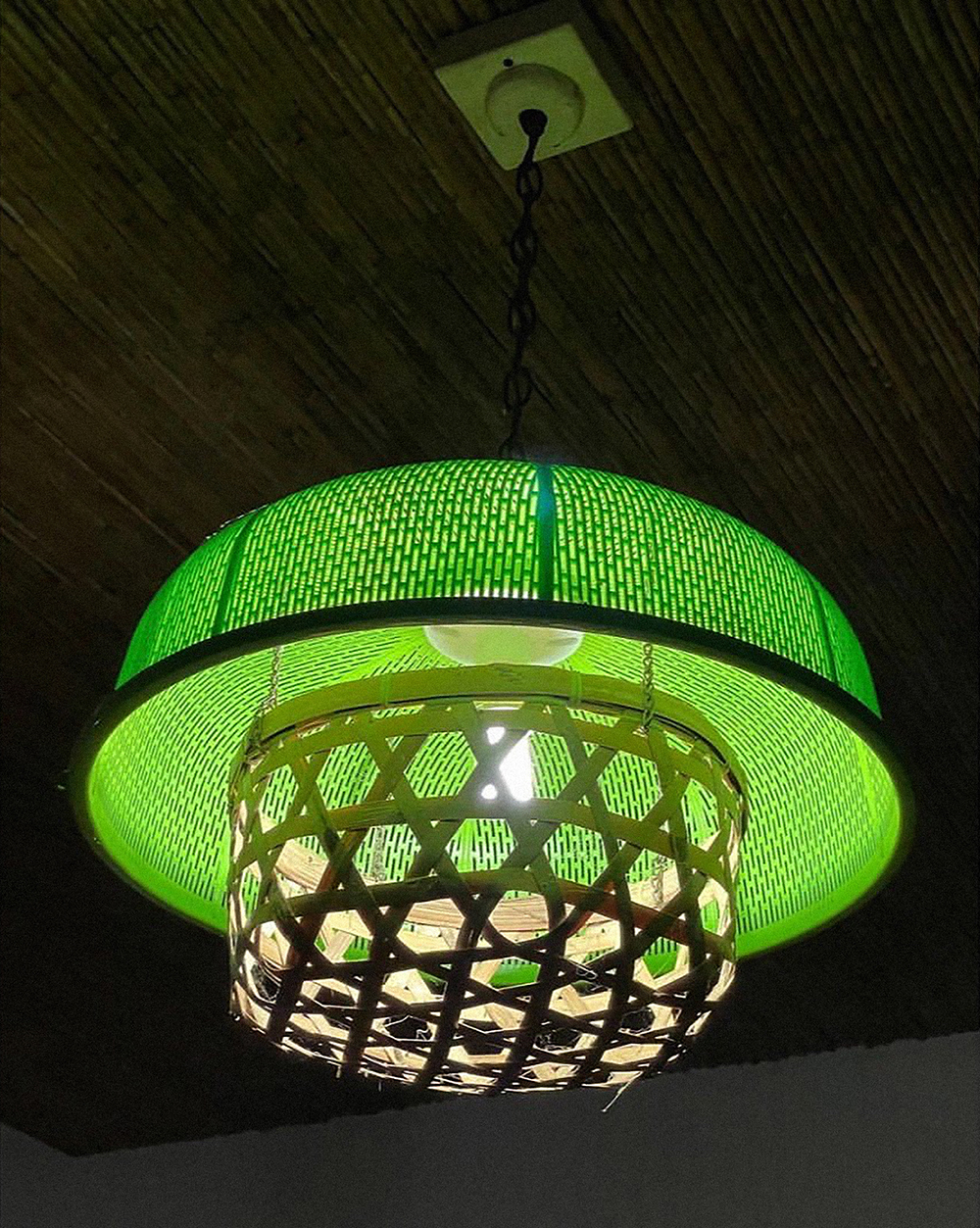 [Weatherproofing] Artist Christina Quisumbing Ramilo's DIY pendant lam made out of baskets, the green plastic one used for covering served food. On hotter days, houseflies seem to be more attracted to food left on the table. Photo by Lenda Cobangbang, taken in Cavite City.