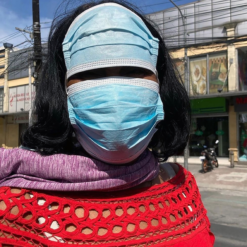 [Weatherproofing] A lady on a sunny street in Quezon City with an extra face mask on her forehead: "Nainitan yung noo ko!" ("My forehead is feeling hot!"). Photo by Jed Escueta.