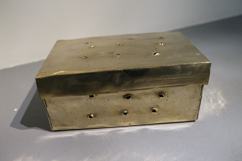 A golden shoebook with holes punctured into the side and top.